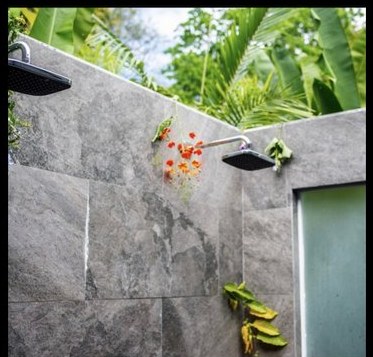 Outdoor sky shower surrounded by jungle plants
